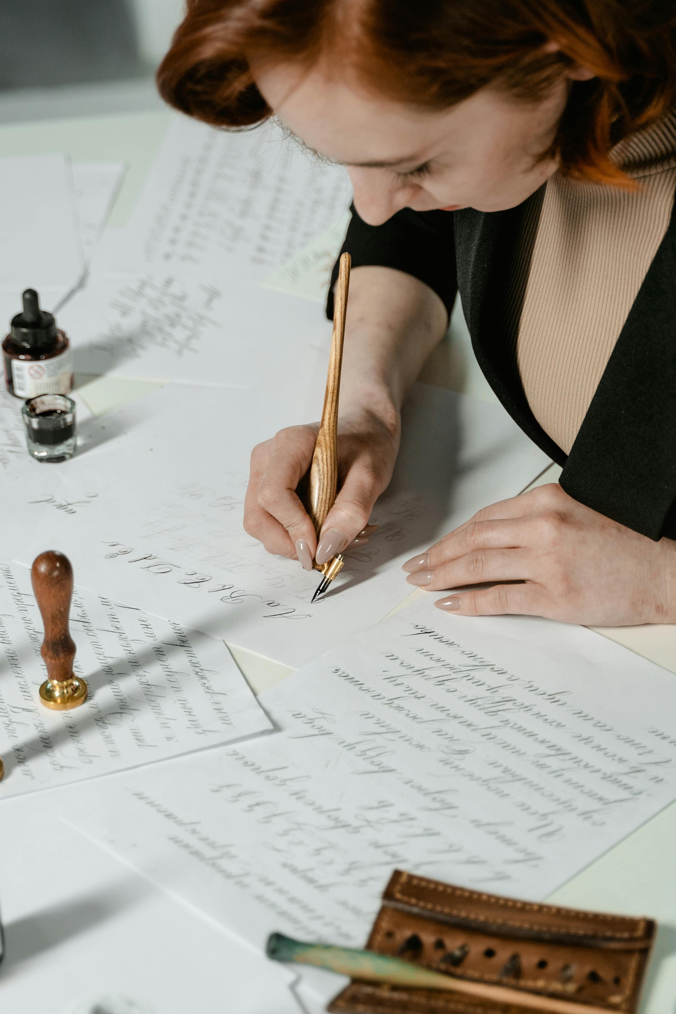 A woman focuses on creating elegant calligraphy using ink and a traditional pen.
