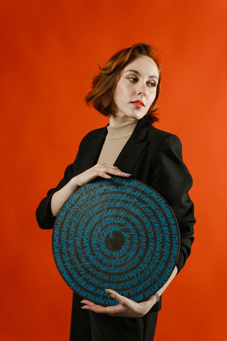 Woman In Black Blazer Holding Brown Round Object 