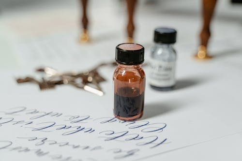 Free Ink Bottle on White Paper Stock Photo