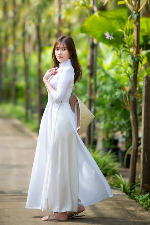 Charming Asian woman in white dress in park
