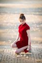 Asian female sitting on haunches and picking up flowers