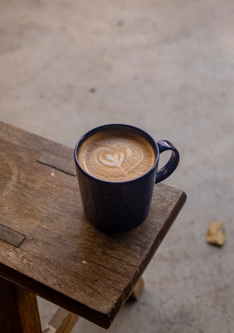 A beautifully crafted cappuccino with latte art served on a rustic wooden table.