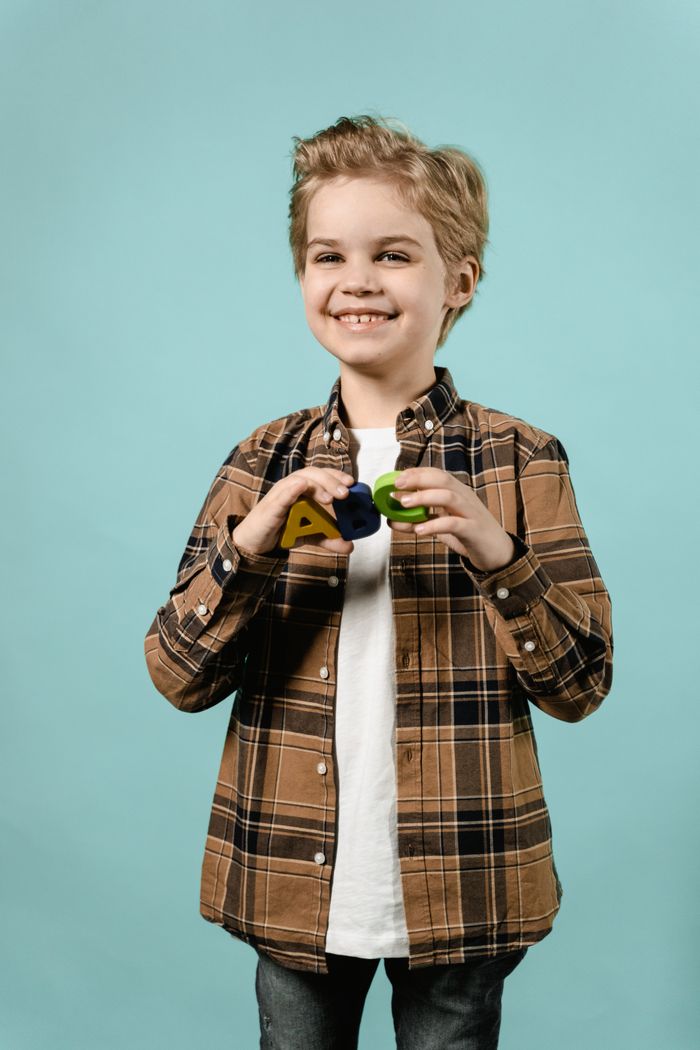 Happy child holding colourful alphabet letters