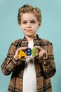 Boy in Brown and Black Plaid Button Up Shirt Holding Green and Blue Plastic Toy