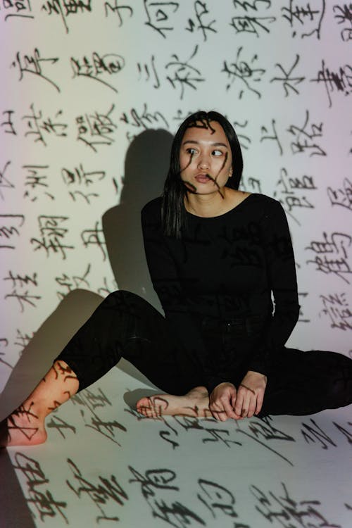 Woman in Black Long Sleeve Shirt and Pants Sitting on the Floor