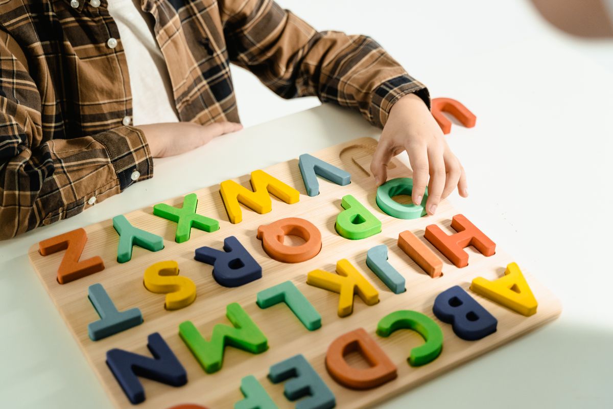 Child using a wooden alphabet learning puzzle