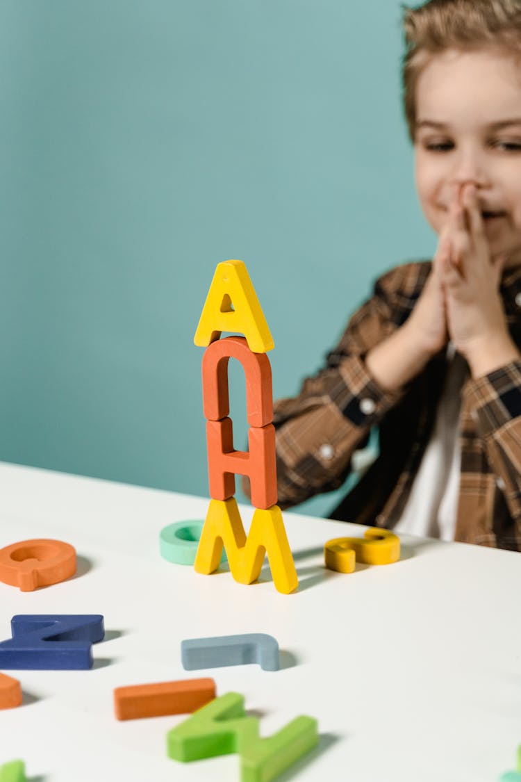 A Young Boy Playing Wooden Letters