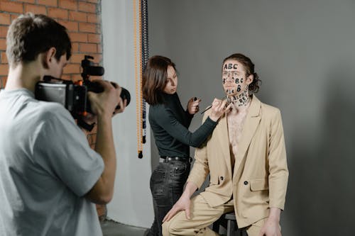 
A Woman Painting Letters on a Man's Face