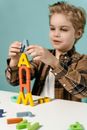Boy in Brown and Black Plaid Button Up Shirt Holding Orange and Yellow Plastic Toy Gun