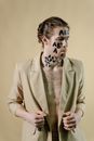 Man in Brown Blazer With White Face Paint