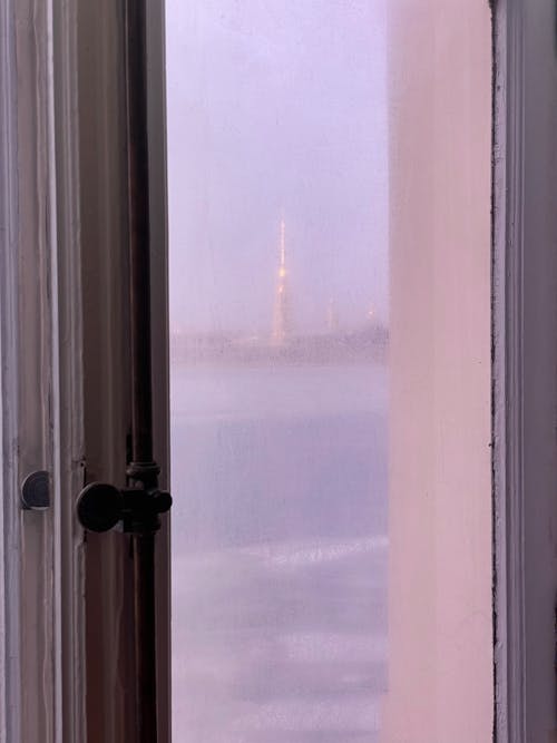 Free View through window in wooden frame on river and high tower located on coast Stock Photo