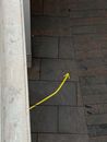 Vivid yellow arrow attracting attention and showing direction painted on tilled ground near building
