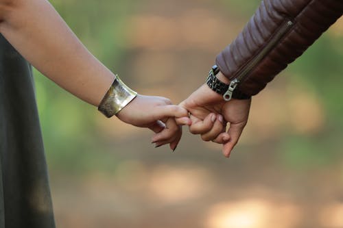 Free Close-up of a couple's hands holding together, showing love and connection. Stock Photo