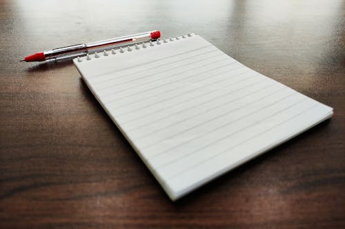 A Notebook and a Pen on a Wooden Table