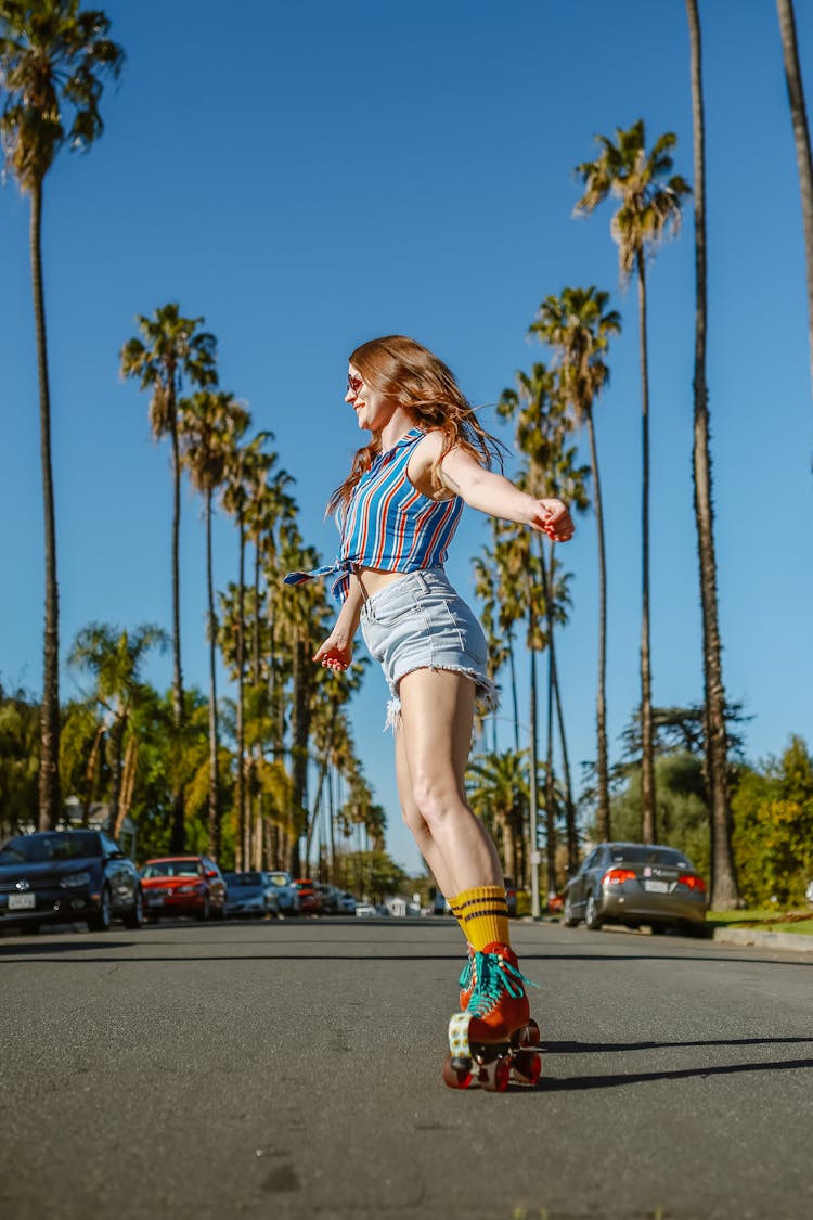 A Woman Roller Skating On A Road 