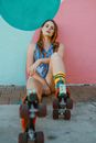 Woman in Blue and White Tank Top and Blue Denim Shorts Sitting on Concrete Floor