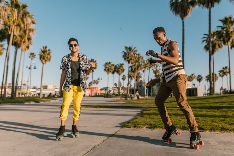 Two Men Wearing Roller Skates In The Park