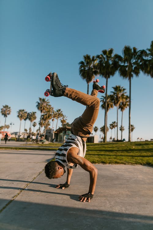 A Man with Roller Skates Hand Standing in the Park
