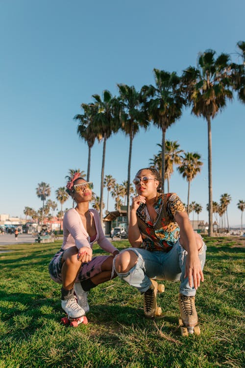 Man and Woman Sitting on Green Grass Field