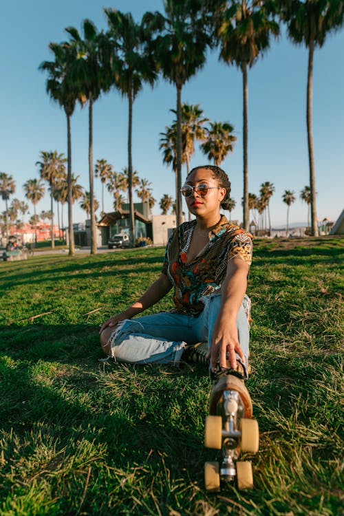 Woman in Sunglasses Sitting on Grass  