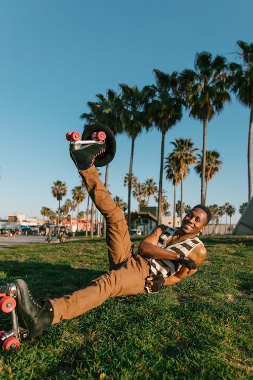 A Man in Brown Pants Lying on Green Grass