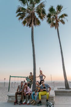 Group of stylish friends roller skating by palm trees at a beach during sunset, capturing a lively and vintage vibe.