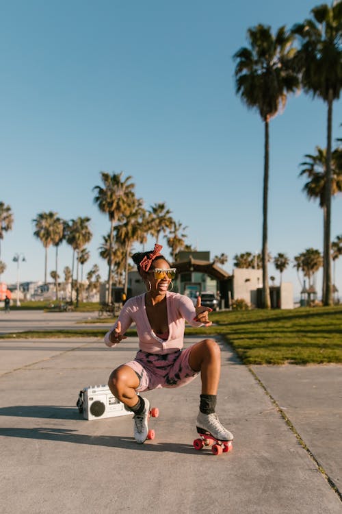 Woman Sitting on Concrete Floor while Wearing Roller Skates