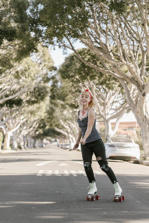 Woman in Black and White Polka Dot Sports Bra and Black Leggings Running on Road during