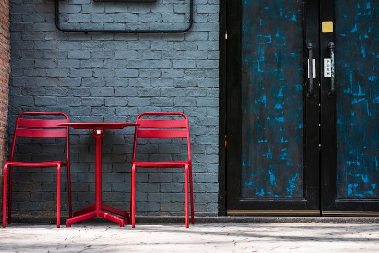 Red Chairs And Coffee Table Standing At Blue Door To Cafeteria