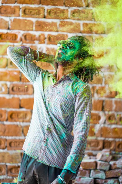 Man in White and Gray Plaid Button Up Shirt With Green Powder on His Face