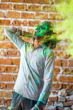 Man enjoying Holi festival with vibrant powder, displaying joyful expression and vivid colors.