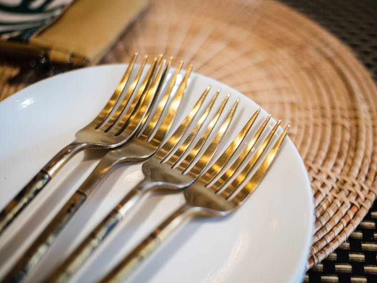 Gold Cutlery On White Plate