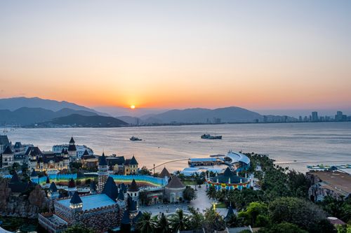 Free Vinwonders park with attractions located in coastal area near sea against cloudless sundown sky and mountain ridge in evening time Stock Photo