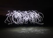 在黑暗的夜晚背景上，长时间曝光的光绘创造出抽象图案