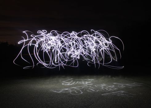 在黑暗的夜晚背景上，长时间曝光的光绘创造出抽象图案