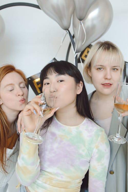 Women Holding Champagne Glasses with Drinks