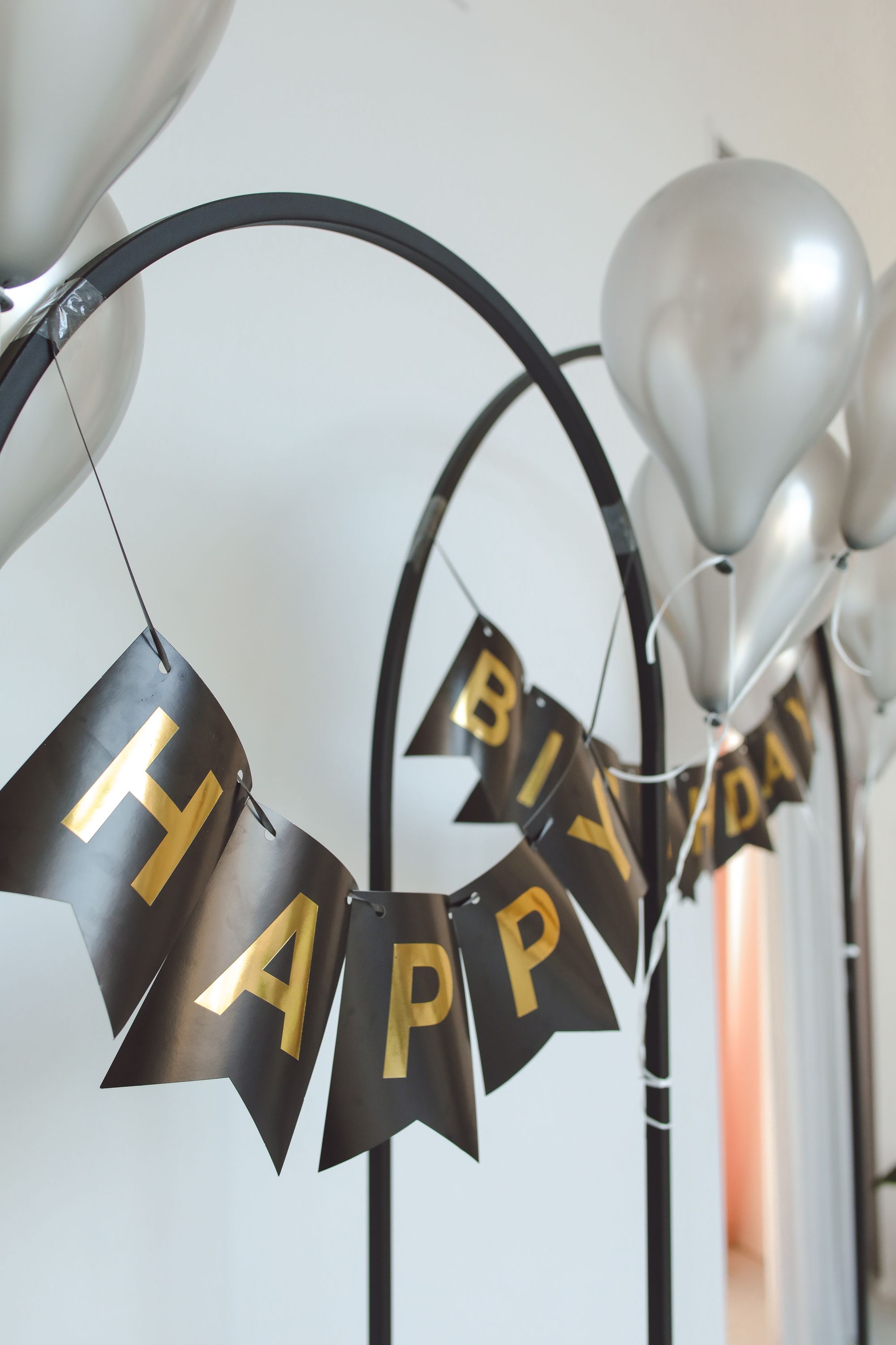 A polished birthday scene arranged with metallic balloons and a celebration banner