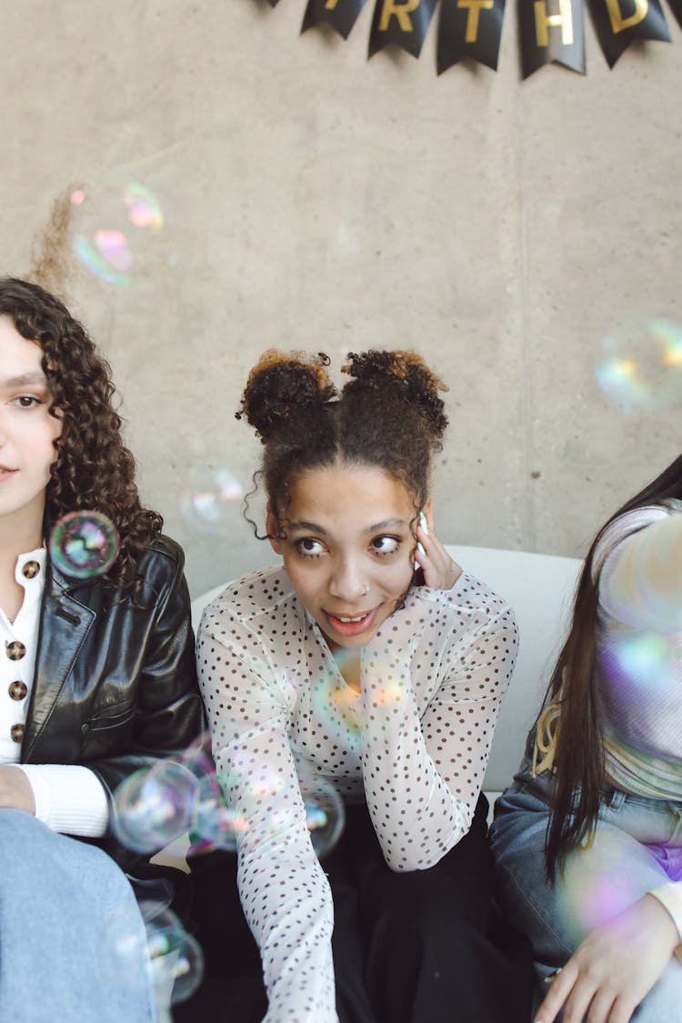 Group Of Young Girls Sitting Next To Each Other At A Birthday Party 