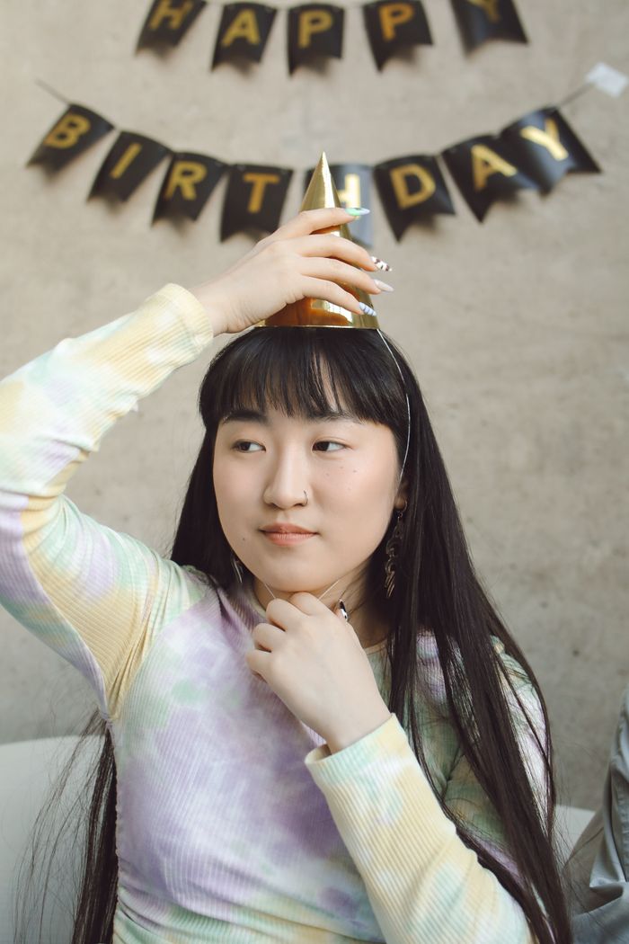 Smiling person in birthday party outfit and hat