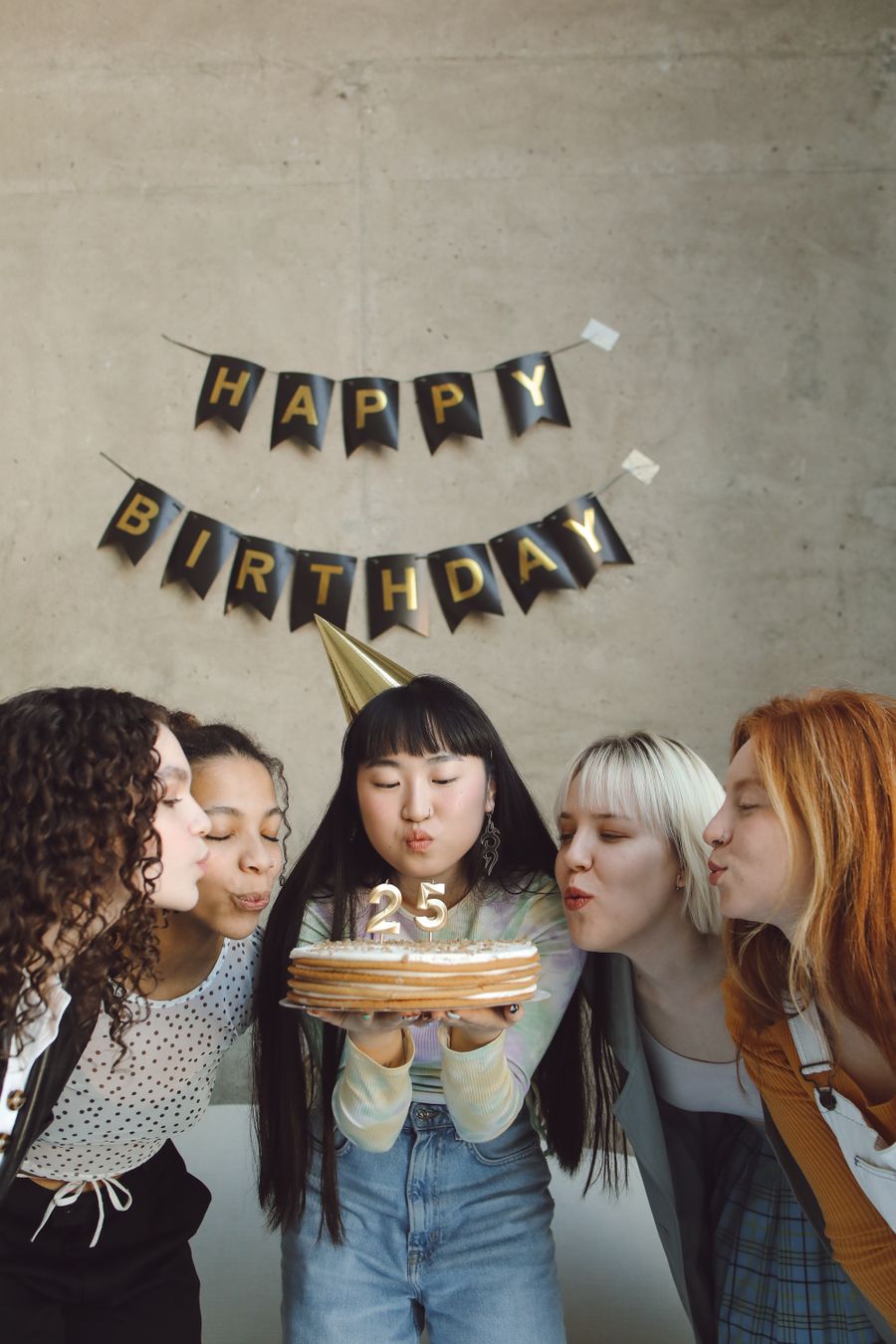 Birthday girl blowing out her candles surrounded by friends