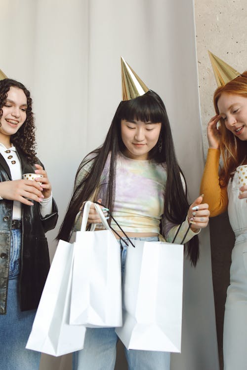 Girl Holding White Paper Bags with Her Friends