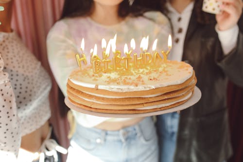 Close-Up Shot of a Person Holding a Birthday Cake