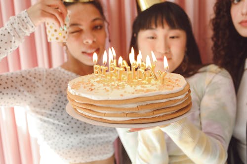 Free Girls Holding a Birthday Cake with Burning Candles  Stock Photo