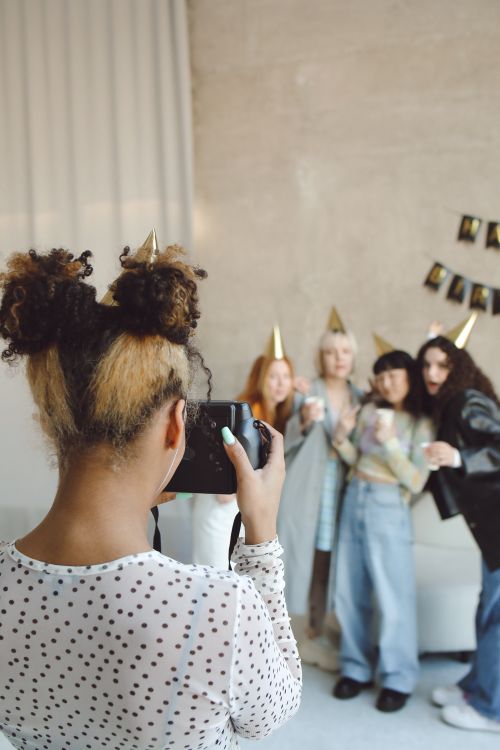 Free A group of friends celebrates a birthday, captured by a young photographer indoors. Stock Photo