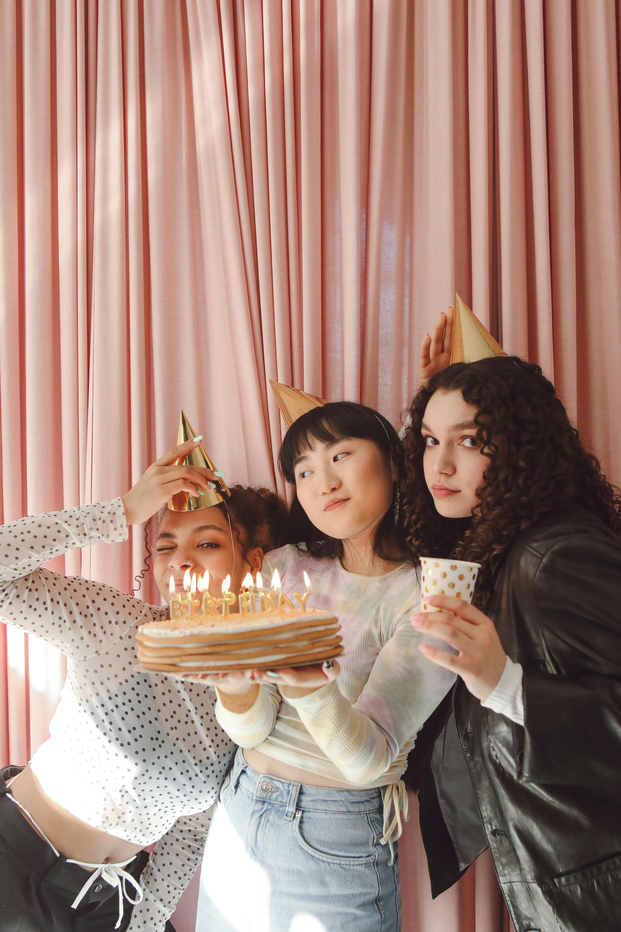 Cute Asian birthday girl looks with temptation at camera licks lips wants  to eat delicious cake has special occasion celebrates 26th bday holds  inflated balloon enjoys festive party poses indoor Stock Photo |