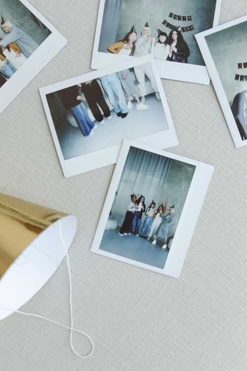 Free Polaroid photos of friends at a casual indoor celebration with festive hats. Stock Photo