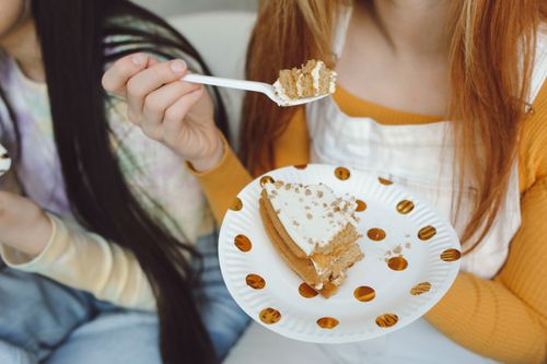 Free Two people indoors eating cake, highlighting sweet dessert enjoyment. Stock Photo