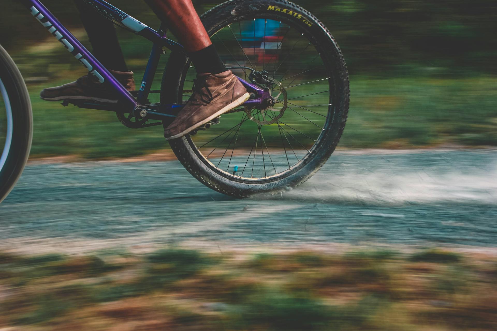 Close-up of a mountain biker speeding on a dusty trail, showcasing motion and excitement.
