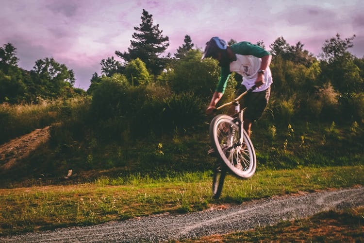 Man In White And Green Raglan Elbow-sleeved Shirt Biking At Daytime