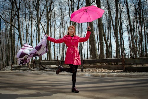 Pretty female in park with umbrella and kerchief